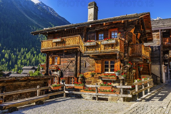 Old wooden house in log construction, decorated with flowers, historic village centre, Grimentz, Val d'Anniviers, Valais Alps, Canton Valais, Switzerland