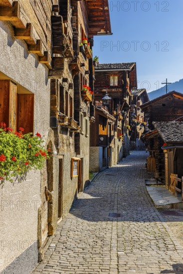 Old wooden houses decorated with flowers, in the village street, historic village centre, Grimentz, Val d'Anniviers, Valais Alps, Canton Valais, Switzerland