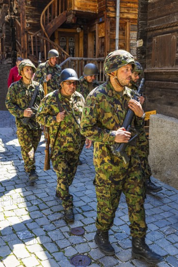 Soldiers from the local heritage society accompany the Corpus Christi procession, historic town centre, Grimentz, Val d'Anniviers, Valais Alps, Canton Valais, Switzerland
