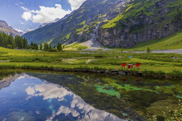 Mountains and clouds reflected in a pond, near Relais Tzoucdana, Zinal, Val d'Anniviers, Valais Alps, Canton Valais, Switzerland
