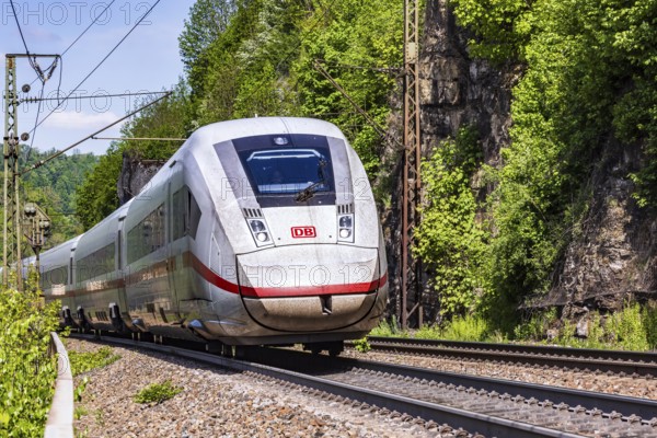 InterCityExpress ICE en route on the winding railway line of the Geislinger Steige. Landscape on the railway's Filstalline line in spring. Amstetten, Baden-Württemberg, Germany