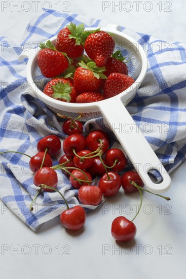 Cherries and strawberries in a colander, fruit