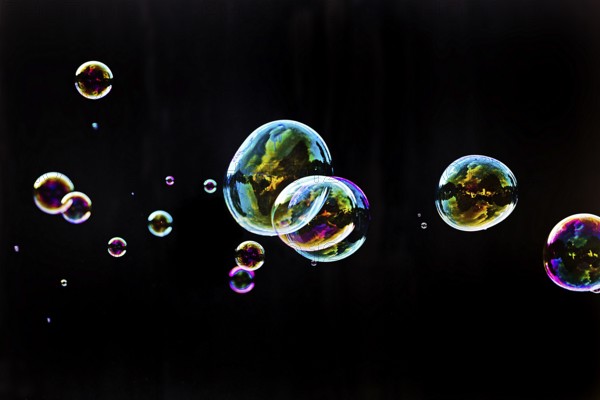 Iridescent soap bubbles in the colours of the rainbow against a black background, Recklinghausen, North Rhine-Westphalia, Germany