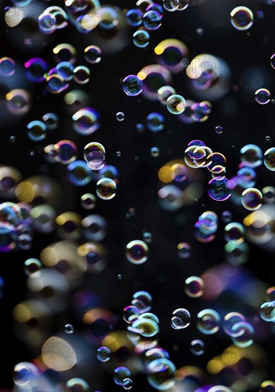 Many, small iridescent and floating soap bubbles against a black background, Recklinghausen, North Rhine-Westphalia, Germany