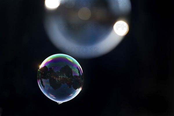 Two shimmering and floating soap bubbles against a black background, Recklinghausen, North Rhine-Westphalia, Germany