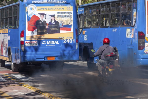 Buses in motion emitting pollution, City of Quito. Pichincha province, Ecuador, South America
