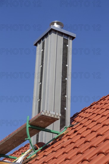 Chimney with high-quality titanium zinc cladding on a straight tiled roof