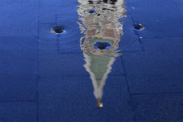 Reflection of the Campanile with water vortex of the flowing flood water, Acqua alta, Venice, Veneto, Italy