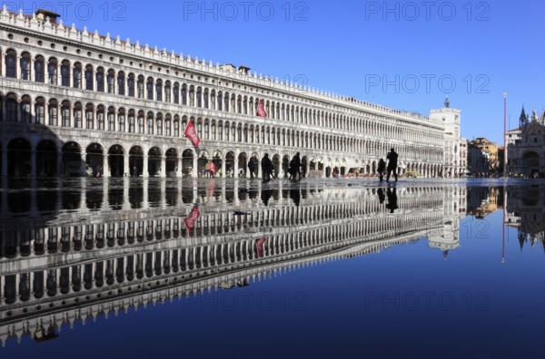 St Mark's Square, reflection of the Procuratie and the clock tower during the Acqua alta, Venice, Veneto, Italy