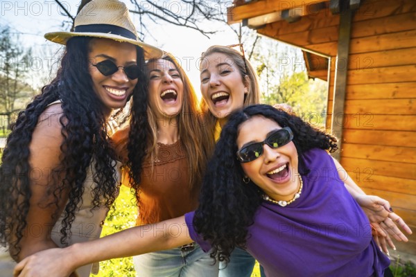 Four multi ethnic female friends are having fun together in a park, laughing and enjoying each other's company