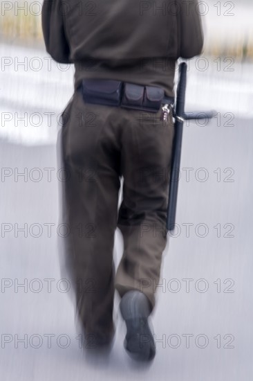 Policeman walking in the street, City of Quito. Pichincha province, Ecuador, South America