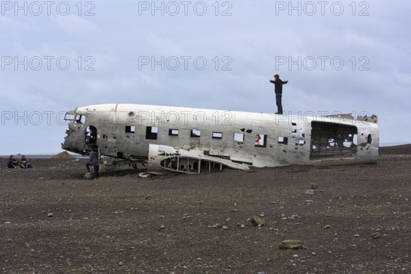 Tourist on aircraft wreckage, US Navy Douglas DC-3 transport plane, Sander, volcanic landscape, Sólheimasandur, Solheimasandur, near ring road, Suðurland, Sudurland, South Iceland, Iceland