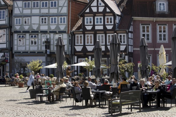 People in the outdoor catering area in the old town with many half-timbered houses, Großer Plan, Celle, Lower Saxony, Germany
