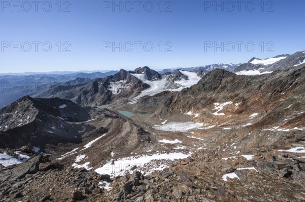 View of mountain basin with blue glacier lakes, behind summit Becher with Becherhaus, glacier Übeltalferner and summit Königshofspitz, descent from summit Wilder Freiger to Roter Grat, Stubai Alps, South Tyrol, Italy