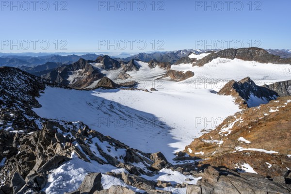 Narrow rocky ridge at the Wilder Freiger summit, picturesque high mountain landscape with snow, view of Übeltalferner glacier and rocky mountain peaks Königshofspitz and Sonklarspitze, Stubai Alps, South Tyrol, Italy