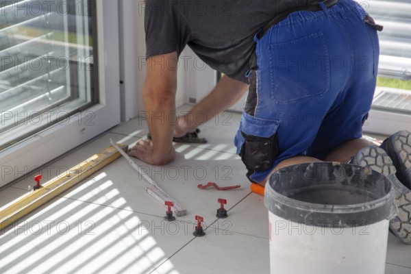 Tiler lays new floor tiles