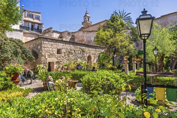 Lush green ornamental garden with visitors at the Arab Baths a historic site in city of Palma a sunny summer day, Arab Baths, Palma de Mallorca, Mallorca, Spain