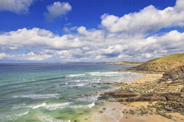 Rocky coastline with breaking waves on the shore and a scenics view to the horizon a sunny summer day with a blue sky and white clouds, Crozon Peninsula, Bretagne, France