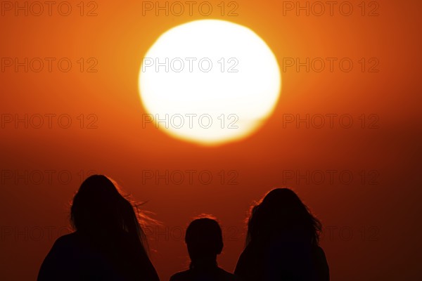 People watching the sun set on the horizon from the summit of the Großer Feldberg in the Taunus, Großer Feldberg in the Taunus, Schmitten, Hesse, Germany