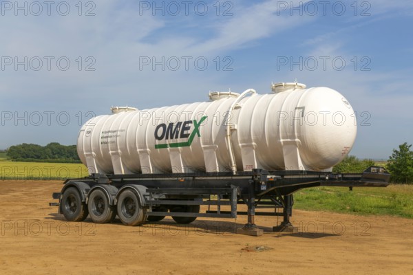 Omex fertiliser road tanker container waggon standing in field, Alderton, Suffolk, England, UK