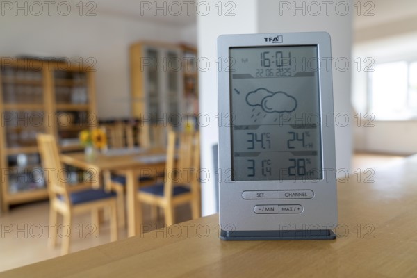 Summer heat, digital thermometer in an attic flat, city centre, outside temperature in the afternoon over 34°C, in the flat 31°C, flat without air conditioning, heats up a lot, health risk, symbolic image climate change