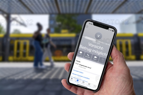 Symbolic image of mobile phone scam, warning of fraudulent calls, here the provider Vodafone, warns the mobile phone user that the caller may have a suspicious number that suggests fraud, spam protection system, the caller's number is stored in a database in which suspicious spam callers are stored, prevention of fraud attempts via mobile phone