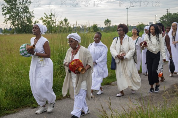 Detroit, Michigan - African-Americans gather on the banks of the Detroit River to commemorate ancestors lost in the slave trade. The annual event, known as The Carnival of the Spirit, is organized by the African Diaspora Ancestral Commemoration Institute