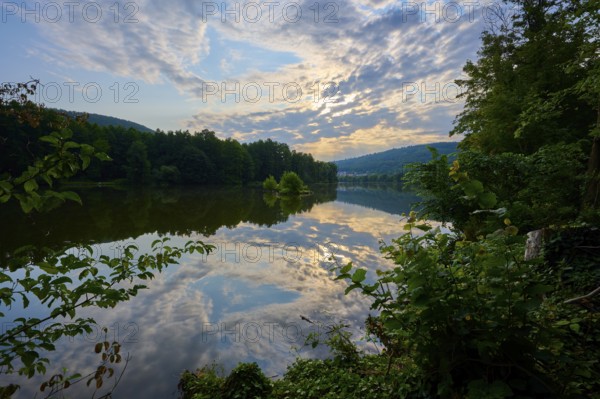 A dramatic sky reflected in a quiet river, surrounded by lush trees, summer, Grünenwört, Wertheim, Main, Main-Tauber-Kreis, Baden-Württemberg, Germany