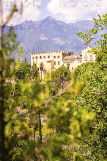 A castle in the middle of a green landscape, in front of a mountain panorama, Botanical Garden, The Gardens of Trauttmansdorff Castle, Merano, South Tyrol, Italy