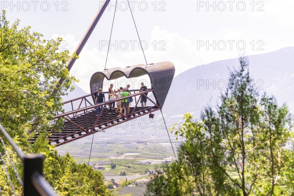Tourists on a floating viewing platform with a mountain landscape in the background, Botanical Gardens, The Gardens of Trauttmansdorff Castle, Merano, South Tyrol, Italy