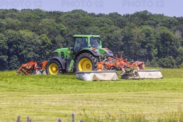 Farmer with tractor mowing a meadow in the Swabian Alb. Merklingen, Baden-Württemberg, Germany