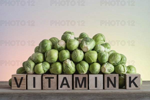 Brussels sprouts stacked on wood with blocks spelling Vitamin K. Rustic studio scene highlighting nutrient-rich greens. Generative ai, AI generated