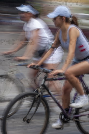 Women riding on bicycles, Photo with motion blur, City of Quito, Pichincha province, Ecuador, South America