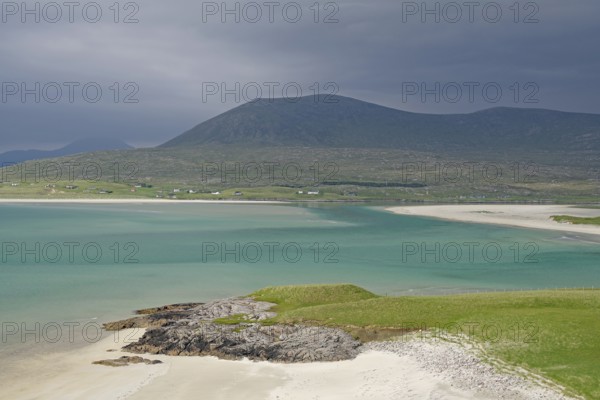 Wide sandy beach meets turquoise waters, surrounded by green hills and mountains under a gloomy sky, Seilebost Beach, Isle of Harris, Hebrides, Scotland, United Kingdom