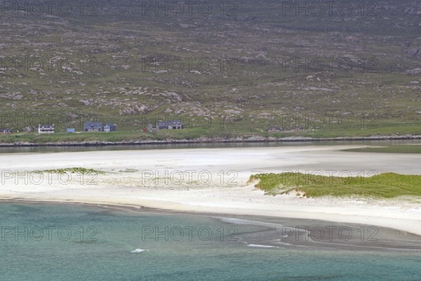 Tranquil coastal landscape with white sand and green land in flat light under a cloudy sky, Seilebost Beach, Isle of Harris, Hebrides, Scotland, United Kingdom