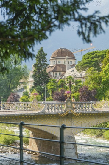 Historic building and bridge with trees in the foreground, Merano, Italy