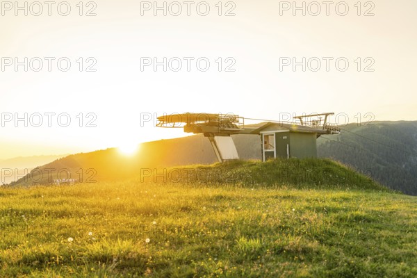 Cable car station in the evening sun with green meadow and mountains in the background, Alpe di Siusi, Dolomites, South Tyrol, Italy