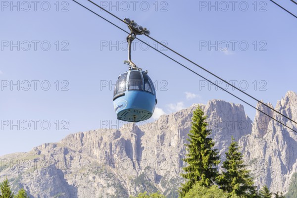 A cable car gondola crosses rocky landscapes against a clear blue sky, Alpe di Siusi, Dolomites, South Tyrol, Italy