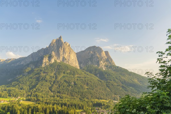Majestic mountains and wooded slopes under a blue sky, Alpe di Siusi, Dolomites, South Tyrol, Italy