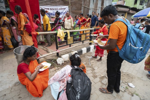 Devotees eating food near a street as they arrives to visit Kamakhya Temple during Ambubachi Mela, in Guwahati, India on June 22, 2025. The Ambubachi Mela is one of the most spiritually significant and culturally unique festivals in India