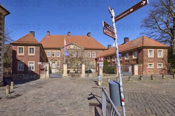 Cathedral administration, brick building, bollards, cobblestone pavement, signpost to Prinzipalmarkt, intersection Spiegelturm with Horsteberg and Domplatz, Münster, Münsterland, independent city, North Rhine-Westphalia, Germany