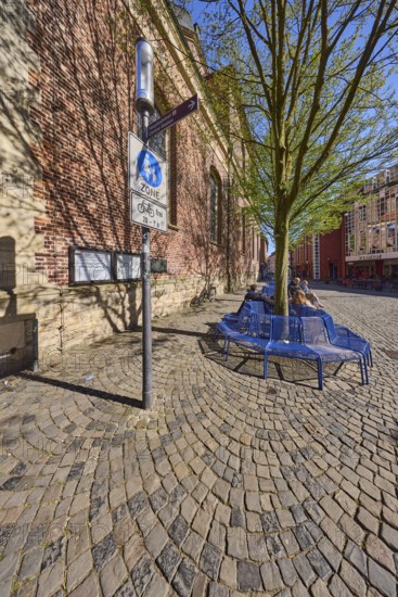 Pedestrian zone, traffic sign, benches, trees, brick building, facade, seated persons as secondary motif, blue cloudless sky, Salzstraße, Münster, Münsterland, independent city, North Rhine-Westphalia, Germany