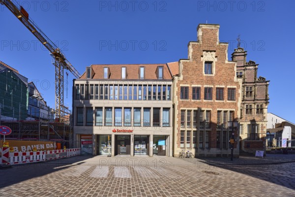 Contrast, modern versus historical architecture, brick building, branch of Santander, facade, window, door, gable, construction site, crane, blue cloudless sky, Alter stony path, Münster, Münsterland, independent city, North Rhine-Westphalia, Germany