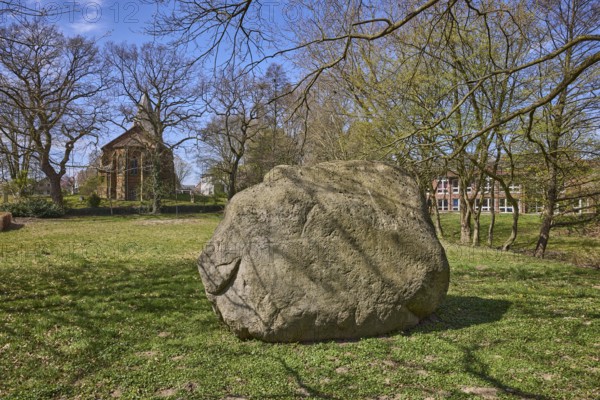 Boulder from southern Sweden, granite, Saale Ice Age, lawn, bare winter trees, blue cloudless sky, Pfarrer-Dustmann-Straße, Bad Oeynhausen, Mühlenkreis Minden-Lübbecke, North Rhine-Westphalia, Germany