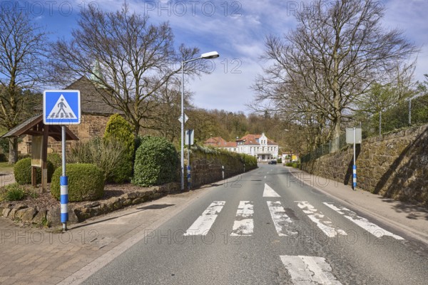 Pedestrian crossing, zebra crossing, traffic sign pedestrian crossing, lantern, bare wintry trees, hedge, pavement, general architecture, forest, blue sky, cumulus clouds, cirrostratus clouds, Volmerdingsener Straße, Bad Oeynhausen, Mühlenkreis Minden-Lübbecke, North Rhine-Westphalia, Germany