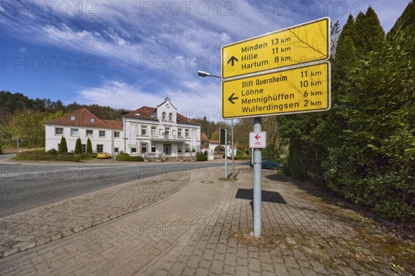 Signposts to Minden, Hille, Hartum, Stift Quernheim, Löhne, Menninghüffen and Wulferdingsen, Hotel and Restaurant Wittekindsquelle, pavement, concrete paving stones, asphalt road, trees, forest, blue sky, cirrostratus clouds, intersection of Volmerdingsener Straße and Bergkirchener Straße, Bad Oeynhausen, Mühlenkreis Minden-Lübbecke, North Rhine-Westphalia, Germany