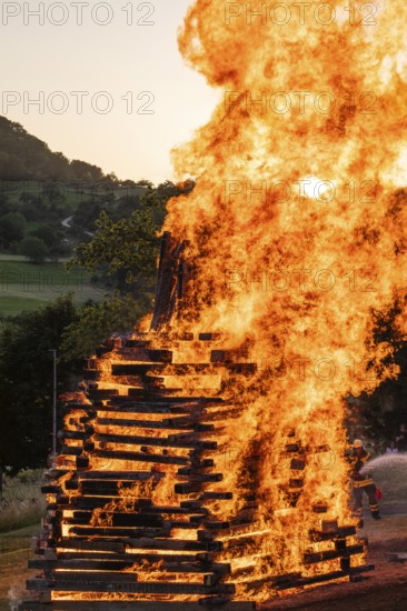 Sunset at a midsummer fire in Germany, Swabian Alb, Lenninger Tal, June 2025, firefighter in the background