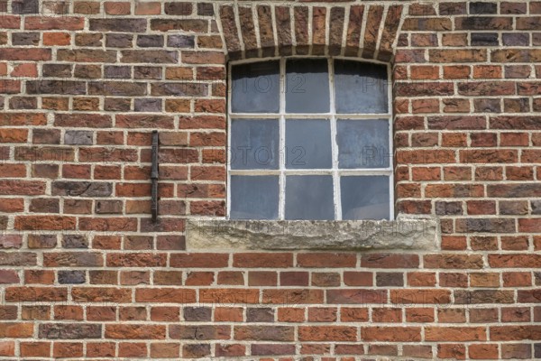 A small, simple window with a round arch in a brick wall, stable window, Legden, Asbeck, Münsterland, North Rhine-Westphalia, Germany