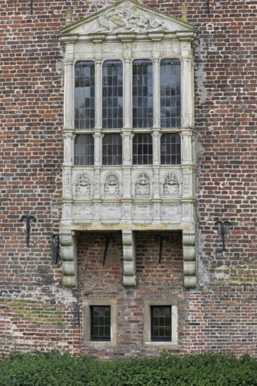 A richly decorated Gothic bay window on an old brick wall, Raesfeld moated castle, Münsterland, North Rhine-Westphalia, Germany