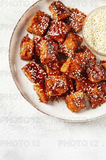 Fried pieces of salmon teriyaki with sesame seeds, top view